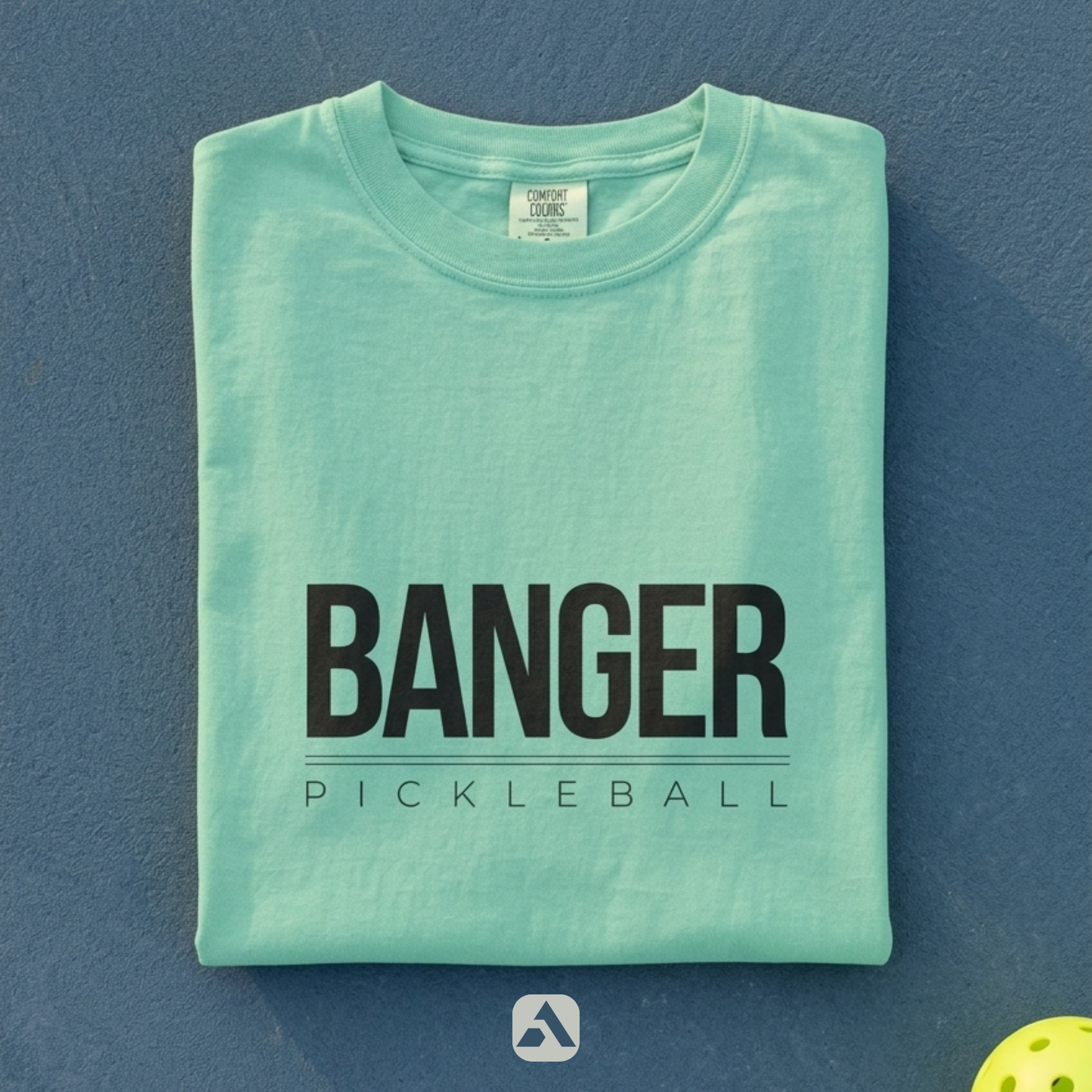 Banger pickleball t-shirt, Island Reef — folded flat-lay with ball