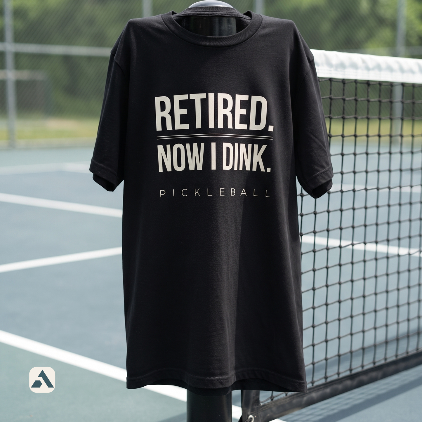 Retired. Now I Dink. pickleball t-shirt, Black — draped over the net